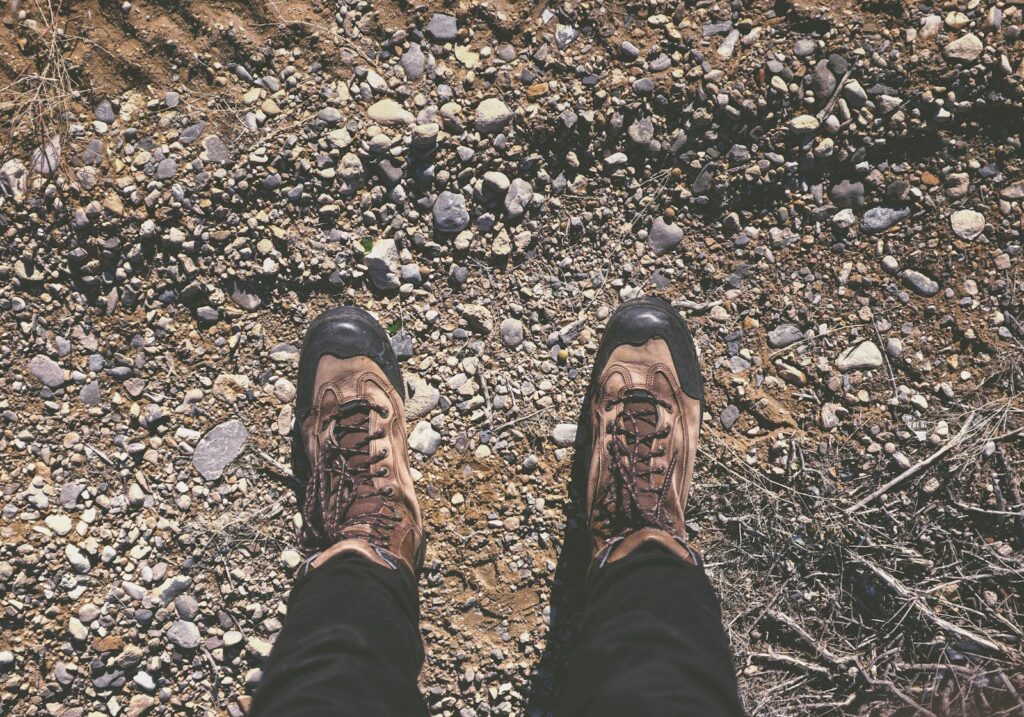 personne portant des chaussures de randonnée sur un sol caillouteux 